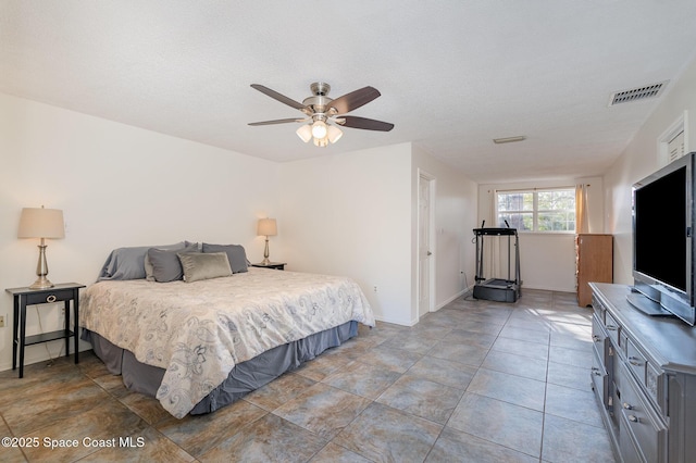 bedroom with ceiling fan and a textured ceiling