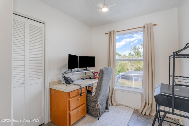 office space featuring a textured ceiling, ceiling fan, and a healthy amount of sunlight