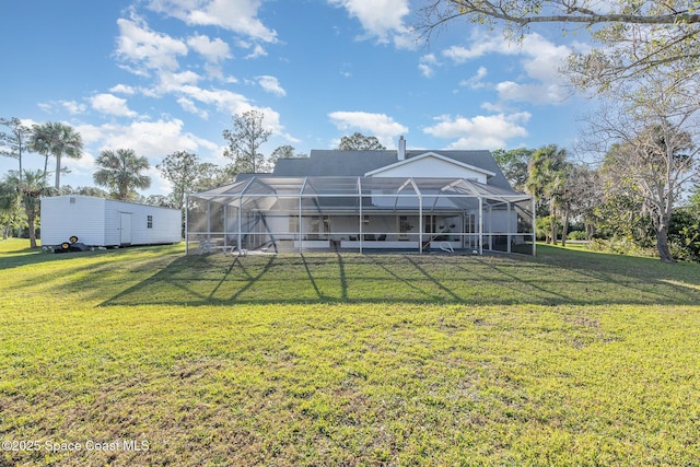 rear view of house with a lanai and a lawn