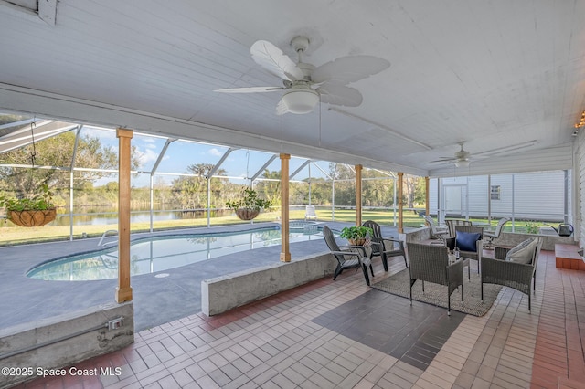 sunroom with ceiling fan, a water view, plenty of natural light, and a swimming pool