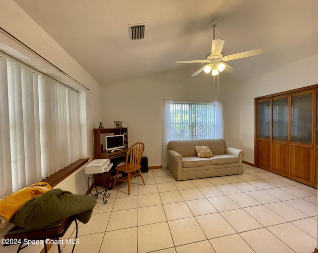 living room featuring ceiling fan, light tile patterned flooring, and lofted ceiling