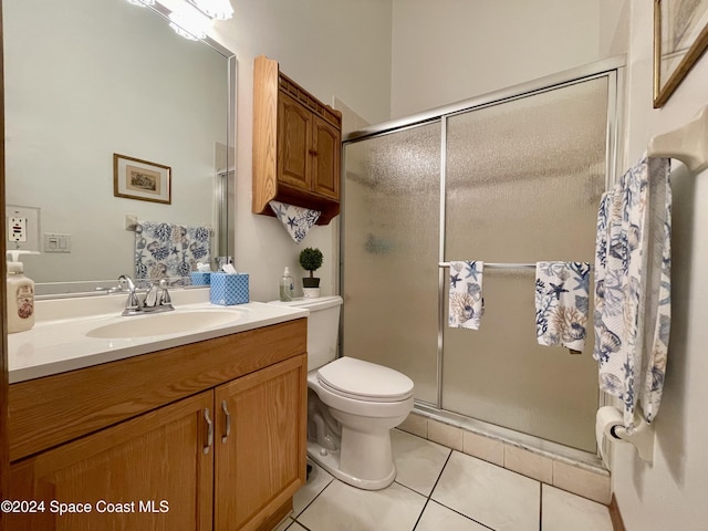 bathroom featuring tile patterned flooring, vanity, an enclosed shower, and toilet