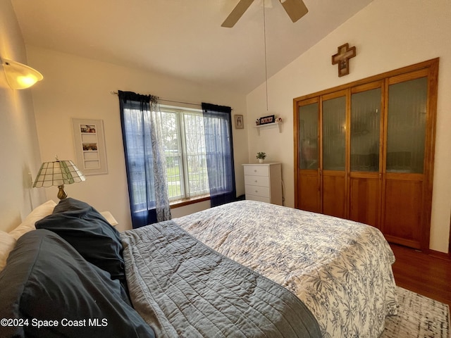 bedroom featuring ceiling fan, wood-type flooring, lofted ceiling, and a closet