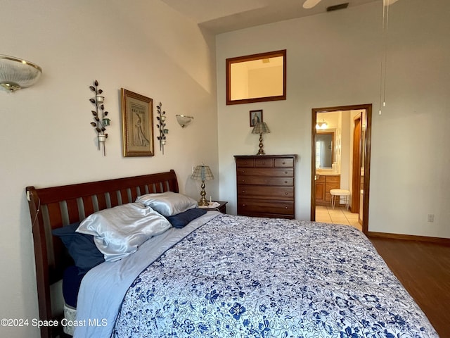 bedroom featuring connected bathroom and hardwood / wood-style flooring