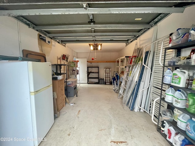 garage featuring white fridge and a garage door opener