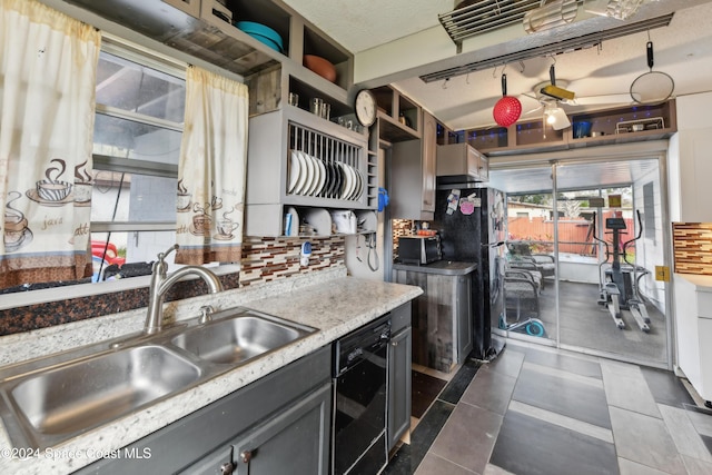 kitchen with gray cabinets, decorative backsplash, sink, and black appliances