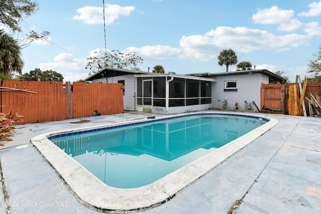 view of swimming pool with a sunroom