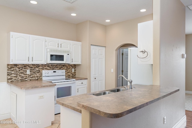 kitchen featuring kitchen peninsula, sink, white cabinets, and white appliances