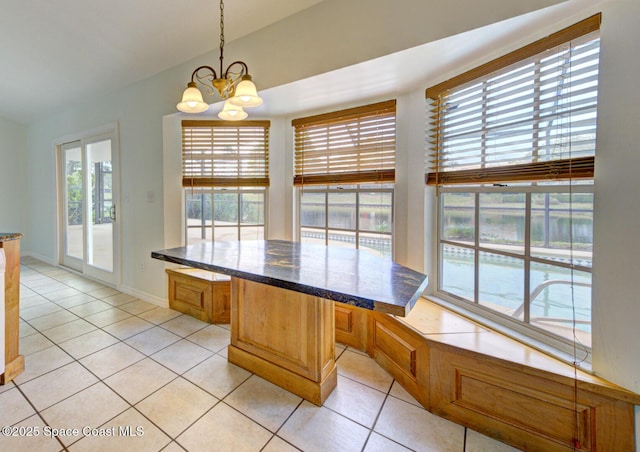 unfurnished dining area with light tile patterned floors and a notable chandelier