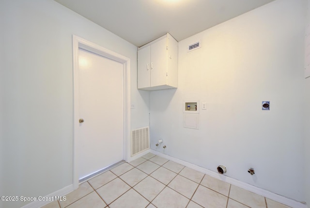 clothes washing area featuring electric dryer hookup, cabinets, hookup for a gas dryer, washer hookup, and light tile patterned floors