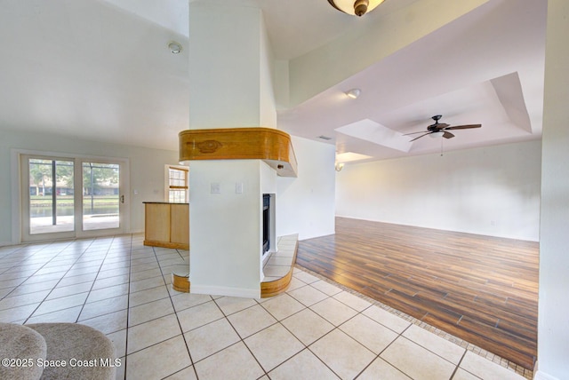 interior space featuring a raised ceiling and ceiling fan