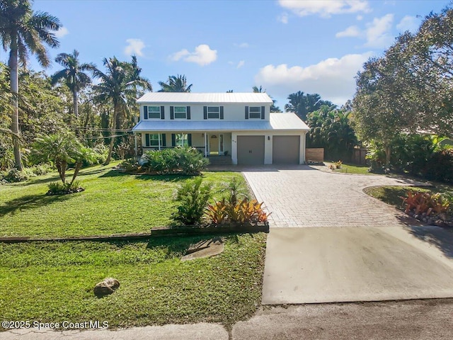 view of front facade featuring a porch, a garage, and a front yard