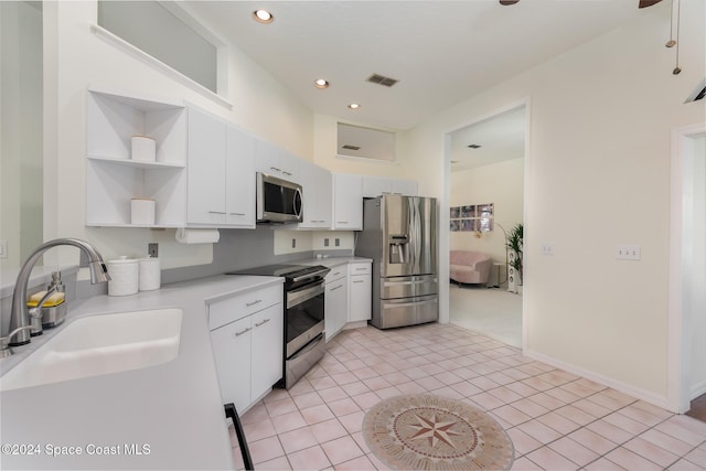 kitchen featuring light tile patterned flooring, appliances with stainless steel finishes, white cabinetry, and sink