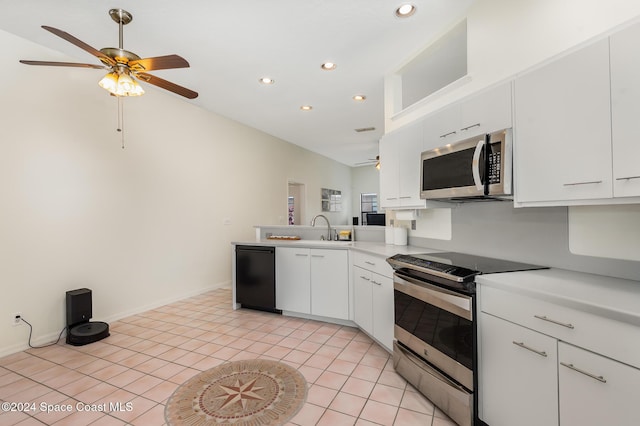 kitchen with sink, light tile patterned floors, vaulted ceiling, white cabinets, and appliances with stainless steel finishes