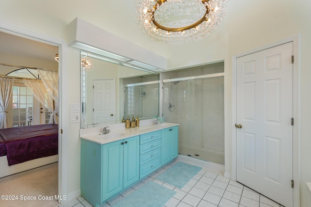 bathroom with a chandelier, vanity, tile patterned floors, and walk in shower