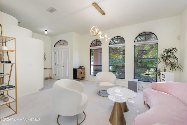 sitting room with light colored carpet and a chandelier