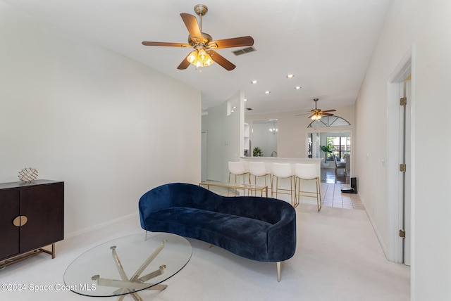 living area featuring light colored carpet and ceiling fan