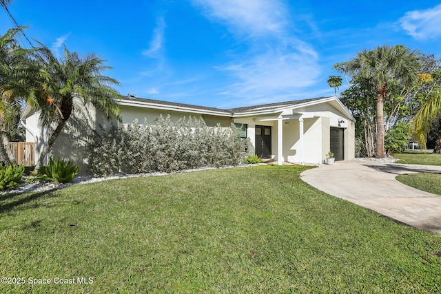 ranch-style house featuring a garage and a front lawn