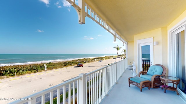 balcony featuring a beach view and a water view