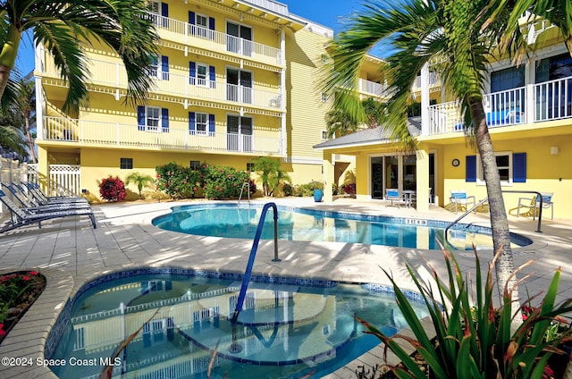 view of swimming pool with a patio area and a hot tub