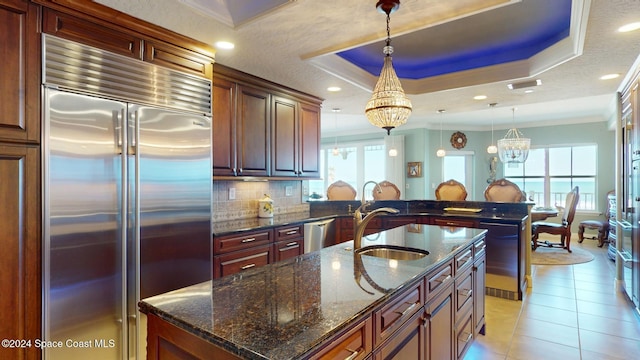 kitchen featuring sink, stainless steel appliances, a raised ceiling, crown molding, and pendant lighting