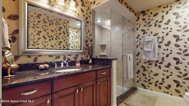 bathroom with tile patterned floors, vanity, toilet, and an enclosed shower