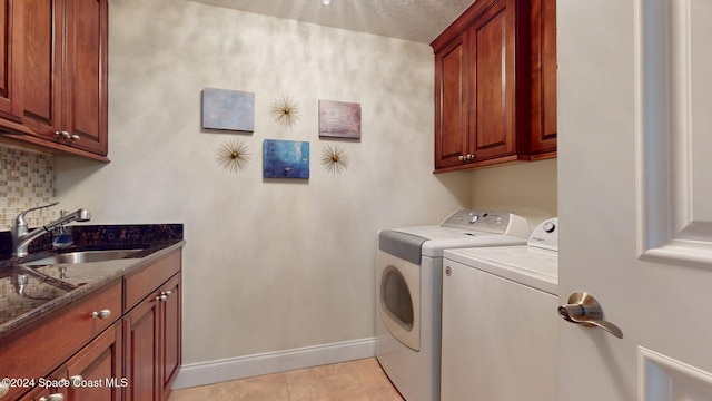 washroom featuring light tile patterned flooring, independent washer and dryer, cabinets, and sink