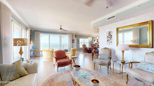 living room featuring ornamental molding, a textured ceiling, ceiling fan, a water view, and light tile patterned flooring