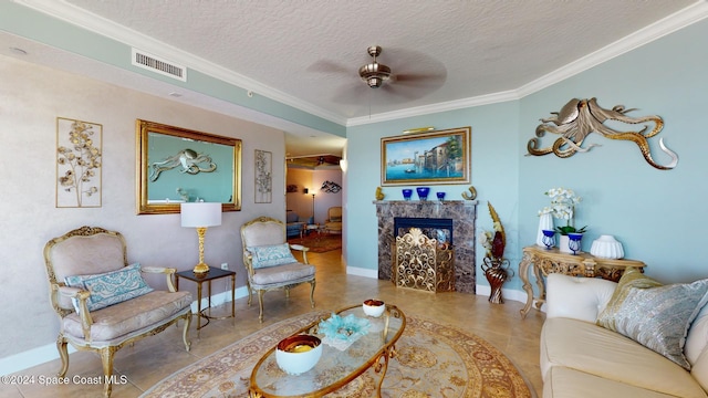 living room with a high end fireplace, tile patterned floors, crown molding, ceiling fan, and a textured ceiling