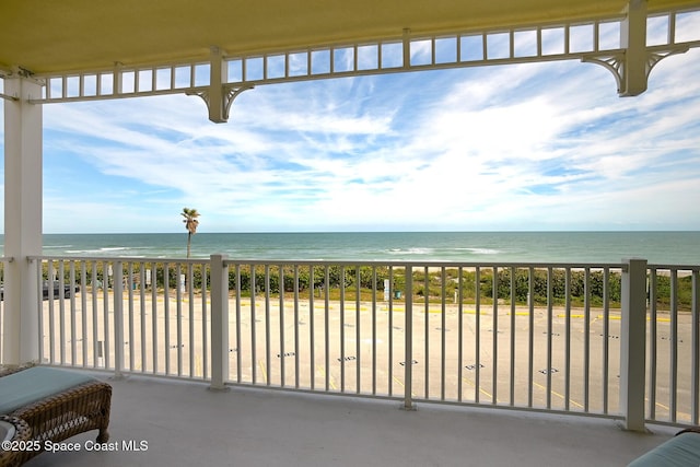 view of patio with a water view and a view of the beach