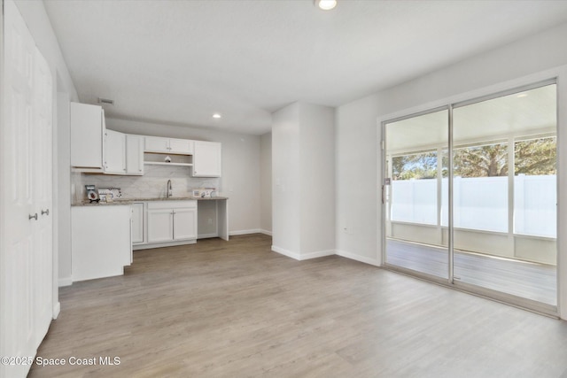 unfurnished living room with light wood-type flooring and sink