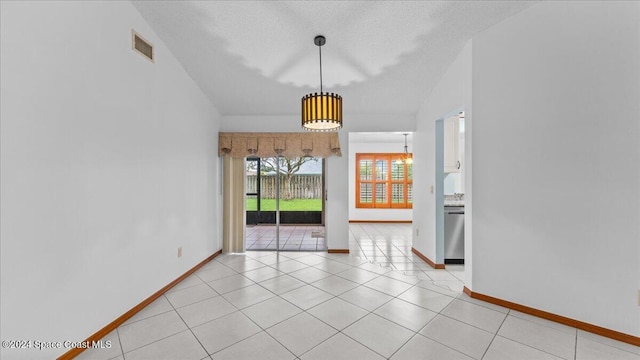 unfurnished dining area featuring light tile patterned floors and a textured ceiling