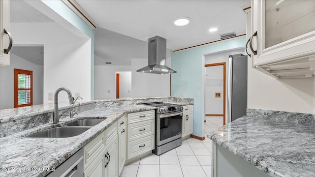 kitchen with sink, wall chimney exhaust hood, light tile patterned floors, light stone countertops, and appliances with stainless steel finishes