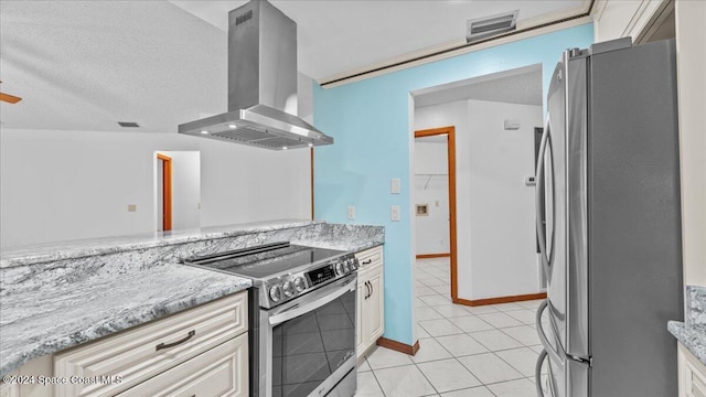 kitchen with wall chimney exhaust hood, a textured ceiling, appliances with stainless steel finishes, light tile patterned flooring, and light stone counters