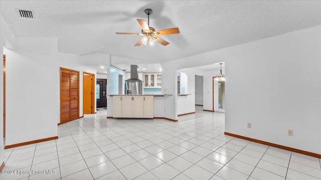 unfurnished living room featuring ceiling fan and a textured ceiling