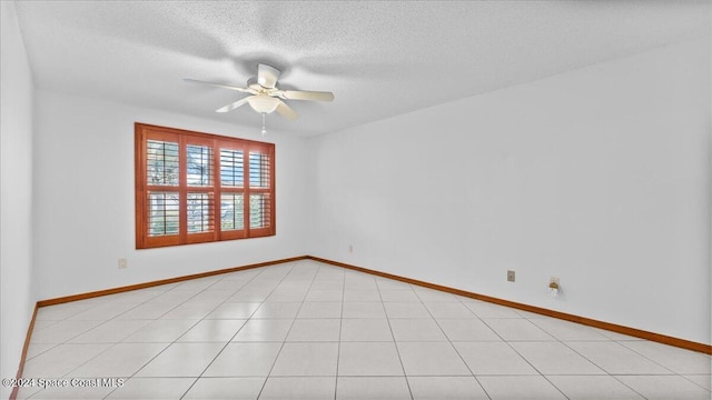 unfurnished room with ceiling fan, light tile patterned flooring, and a textured ceiling