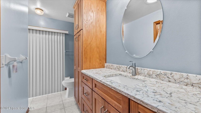 bathroom with tile patterned flooring, vanity, and toilet