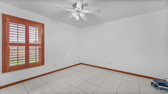 tiled empty room featuring a textured ceiling, ceiling fan, and a healthy amount of sunlight