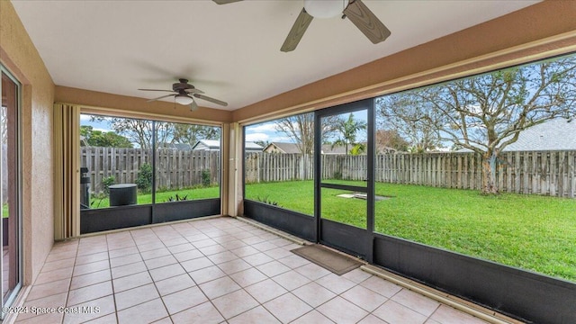 unfurnished sunroom featuring ceiling fan