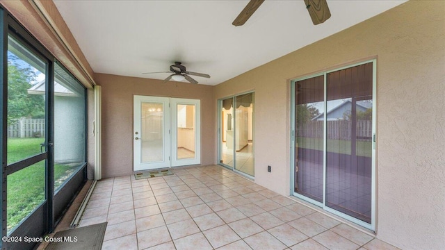 unfurnished sunroom featuring ceiling fan