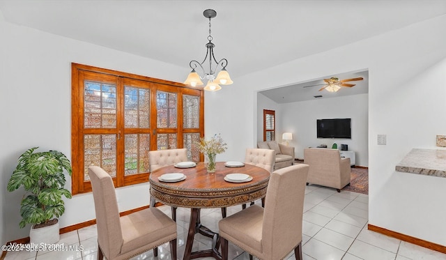 tiled dining area with ceiling fan with notable chandelier