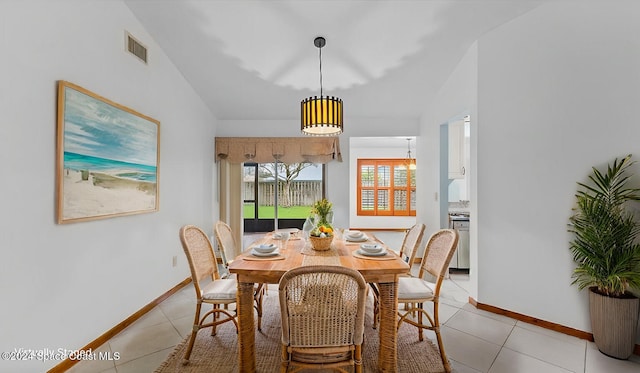 dining area with light tile patterned floors and lofted ceiling