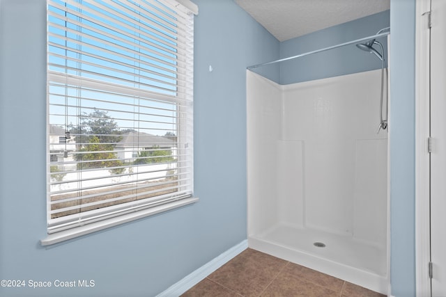 bathroom featuring tile patterned floors, a textured ceiling, and walk in shower