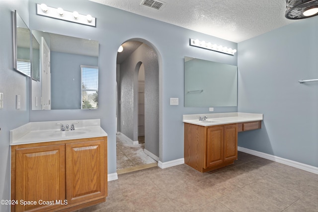 bathroom featuring vanity, a textured ceiling, and walk in shower