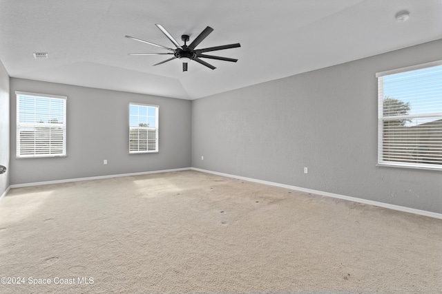 spare room with carpet floors, a tray ceiling, and ceiling fan