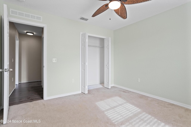 unfurnished bedroom featuring a closet, light colored carpet, and ceiling fan