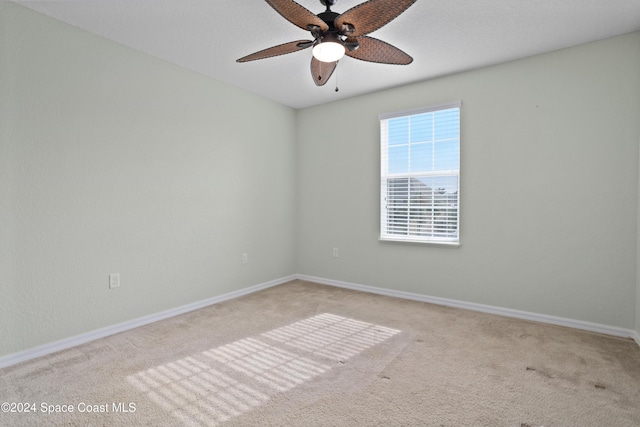 carpeted spare room with ceiling fan