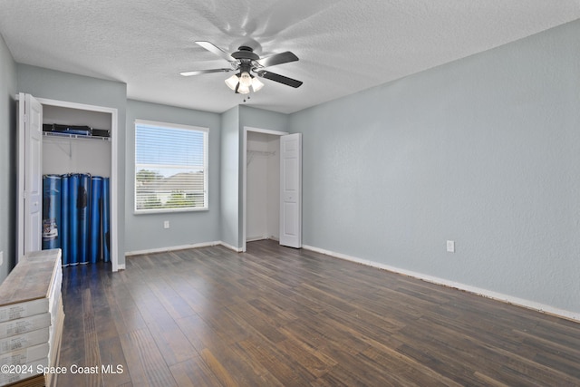 unfurnished bedroom featuring a textured ceiling, dark hardwood / wood-style flooring, and ceiling fan