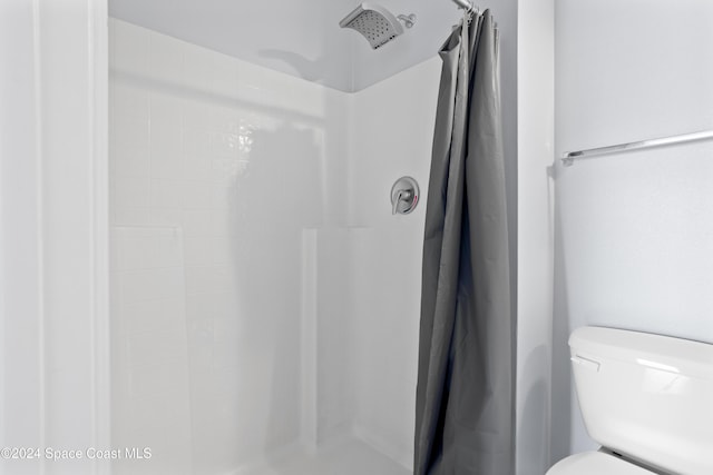 bathroom with a shower with curtain and toilet