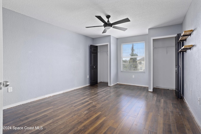 unfurnished bedroom with ceiling fan, dark hardwood / wood-style flooring, and a textured ceiling